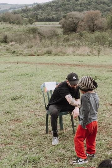 Matheus conversando com um menino no campo